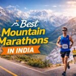 Runners competing in a mountain marathon in India with snow capped Himalayan peaks and winding hill road