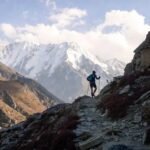 Trail runner climbing rocky Himalayan path during ultra marathon in India, stunning mountain peaks and alpine terrain 2026
