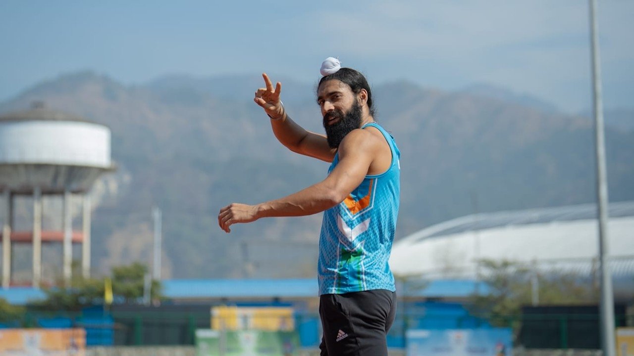 Gurindervir Singh in India athletics vest during training session, flashing a victory sign