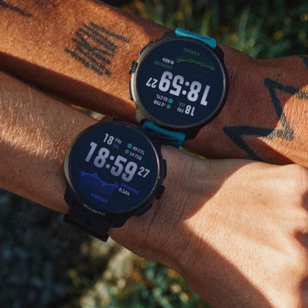 Suunto Race 2 smartwatches on two wrists displaying exercise time and training stress balance.