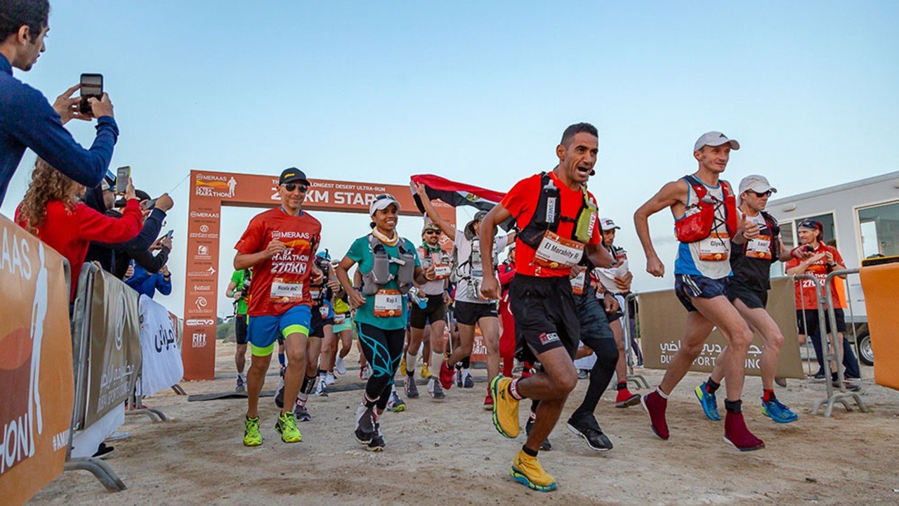 Al Marmoom Ultramarathon 2026: Race Guide (10KM + 5KM December Edition) 2 Runners racing through the Al Marmoom Desert Conservation Reserve during the Al Marmoom Ultramarathon in Dubai