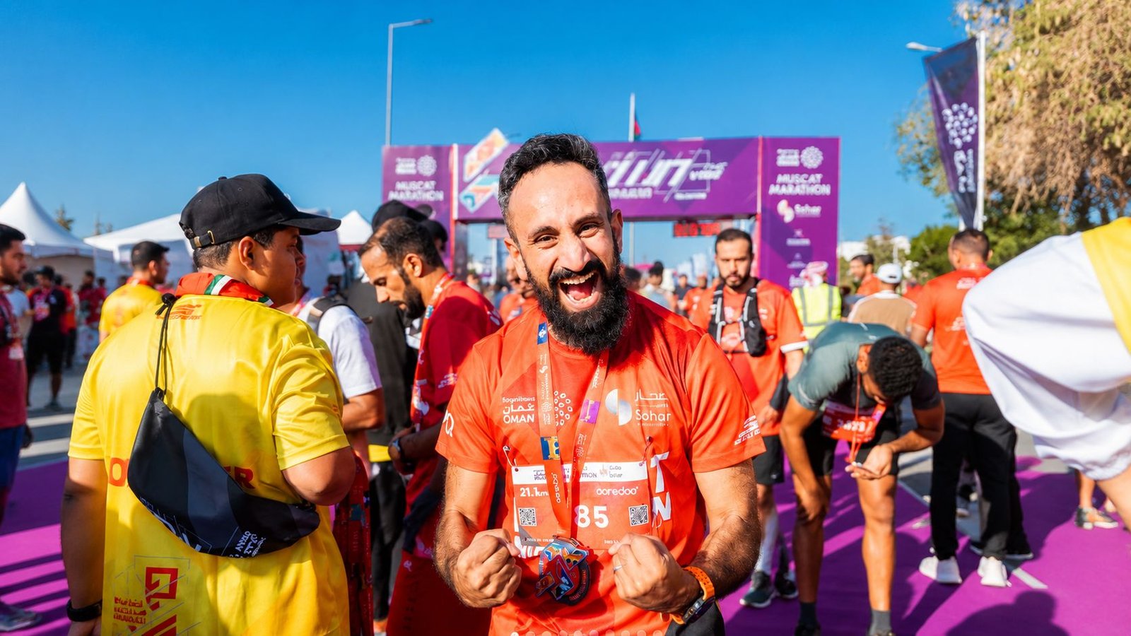 Runner celebrating after crossing the finish line at the Al Mouj Muscat Marathon in Muscat, Oman.