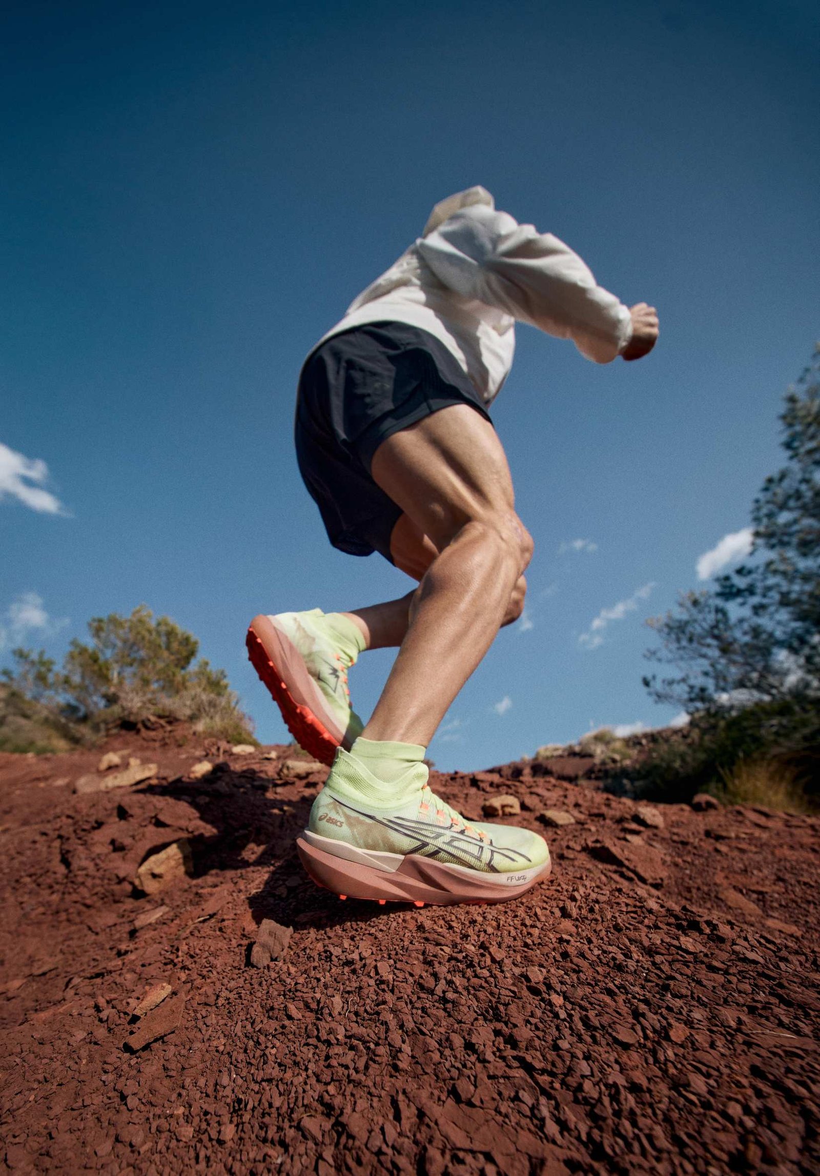 ASICS Metafuji Trail 2 in lime green and coral colorway on red rocky trail terrain