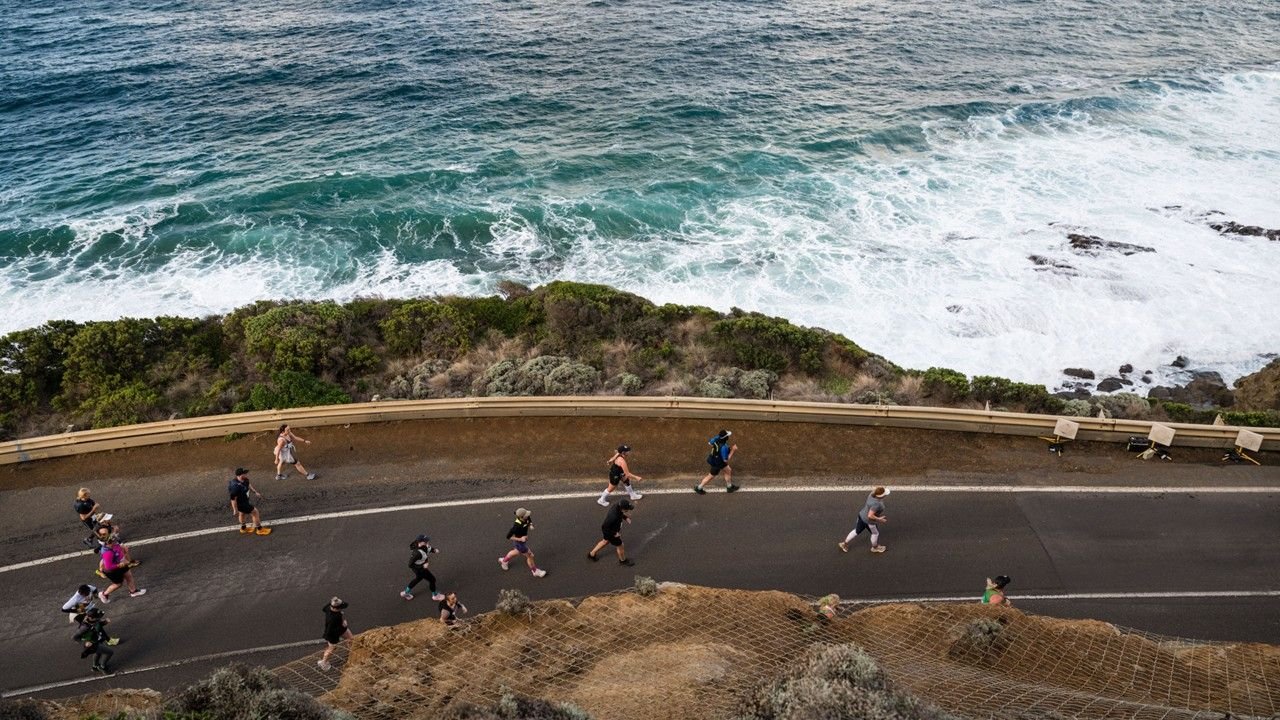 Runners racing along the Great Ocean Road during the Great Ocean Road Running Festival, with the Southern Ocean visible in the background, Victoria Australia
