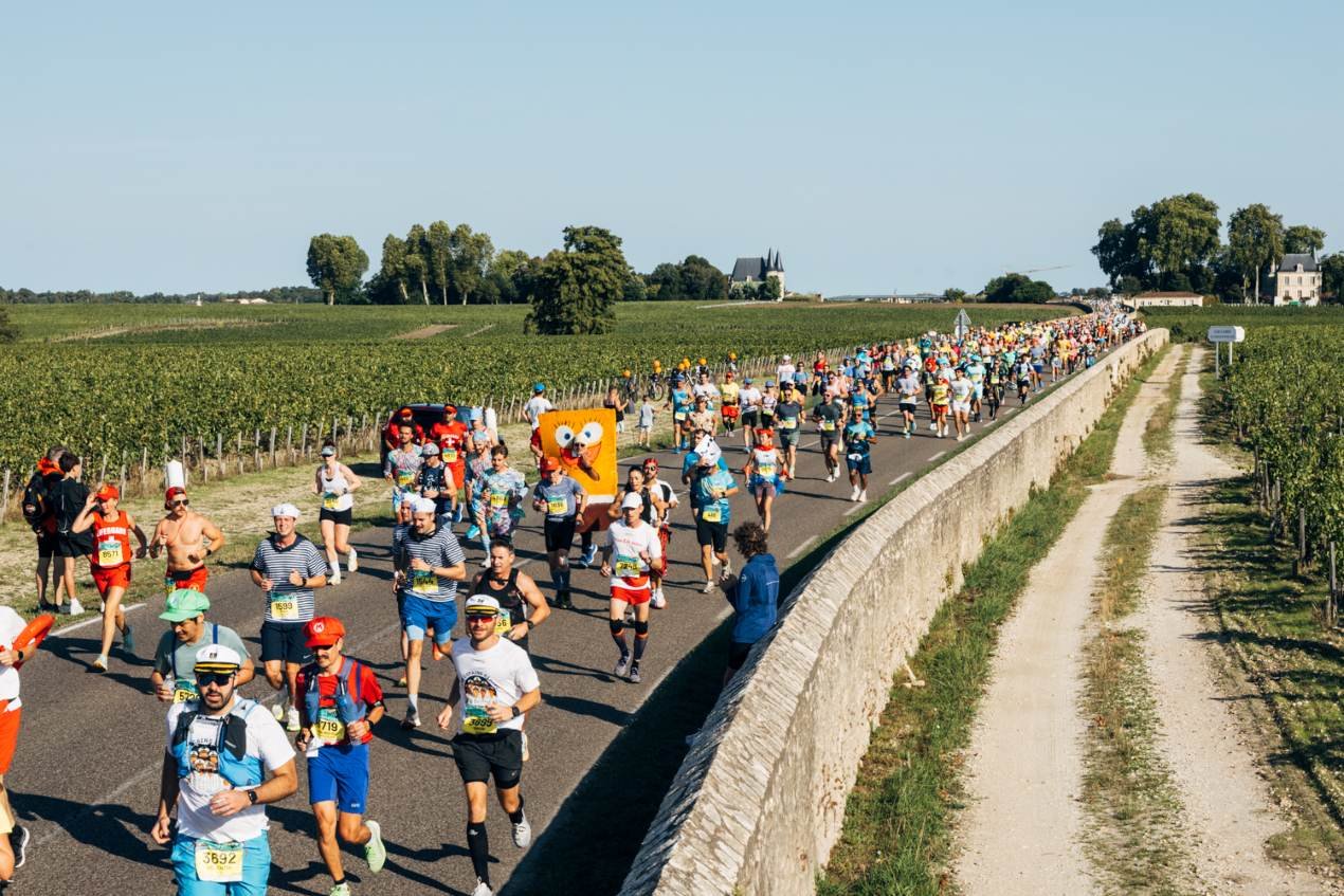Runners in fancy dress at the Marathon du Médoc, passing through Bordeaux wine châteaux country