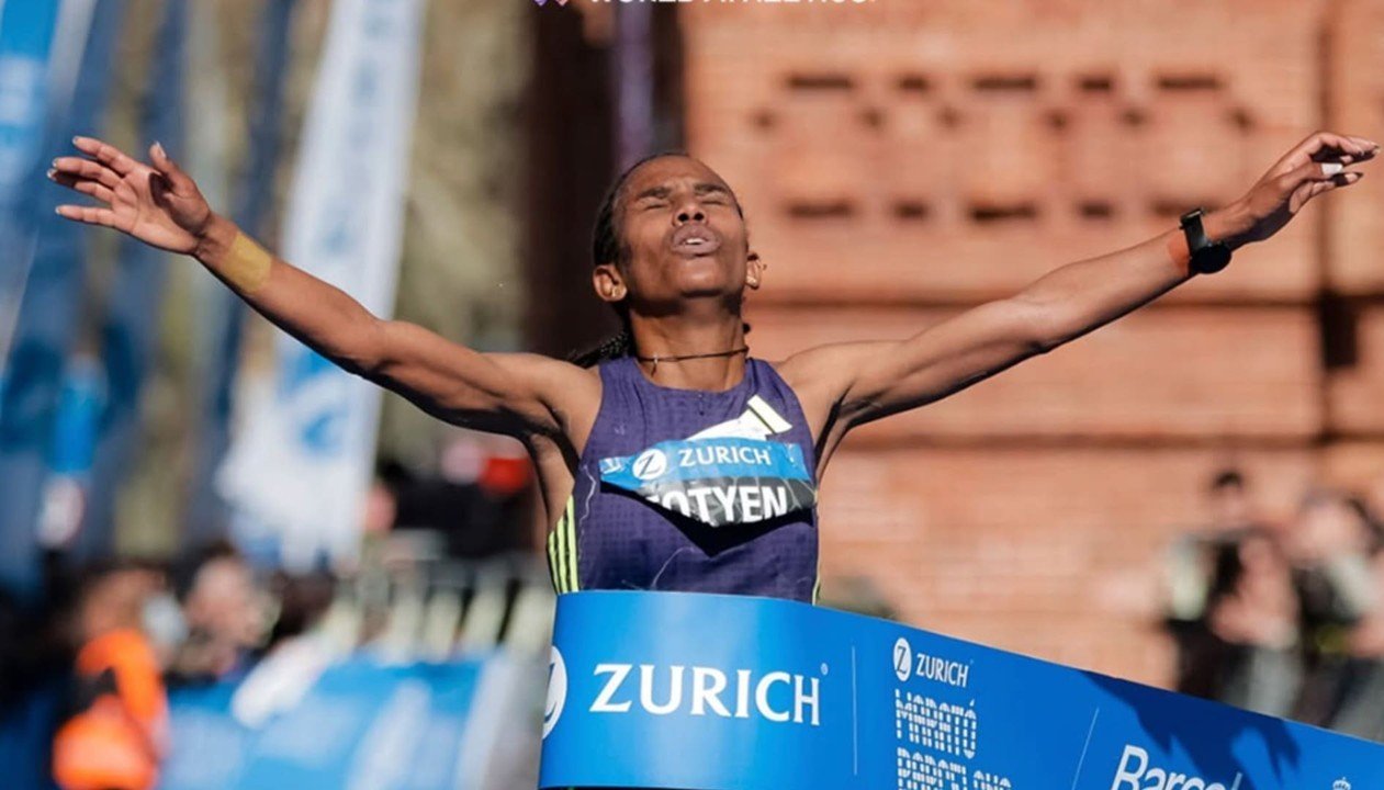 Runners crossing the finish line at the Zurich Barcelona Marathon under the Arc de Triomf