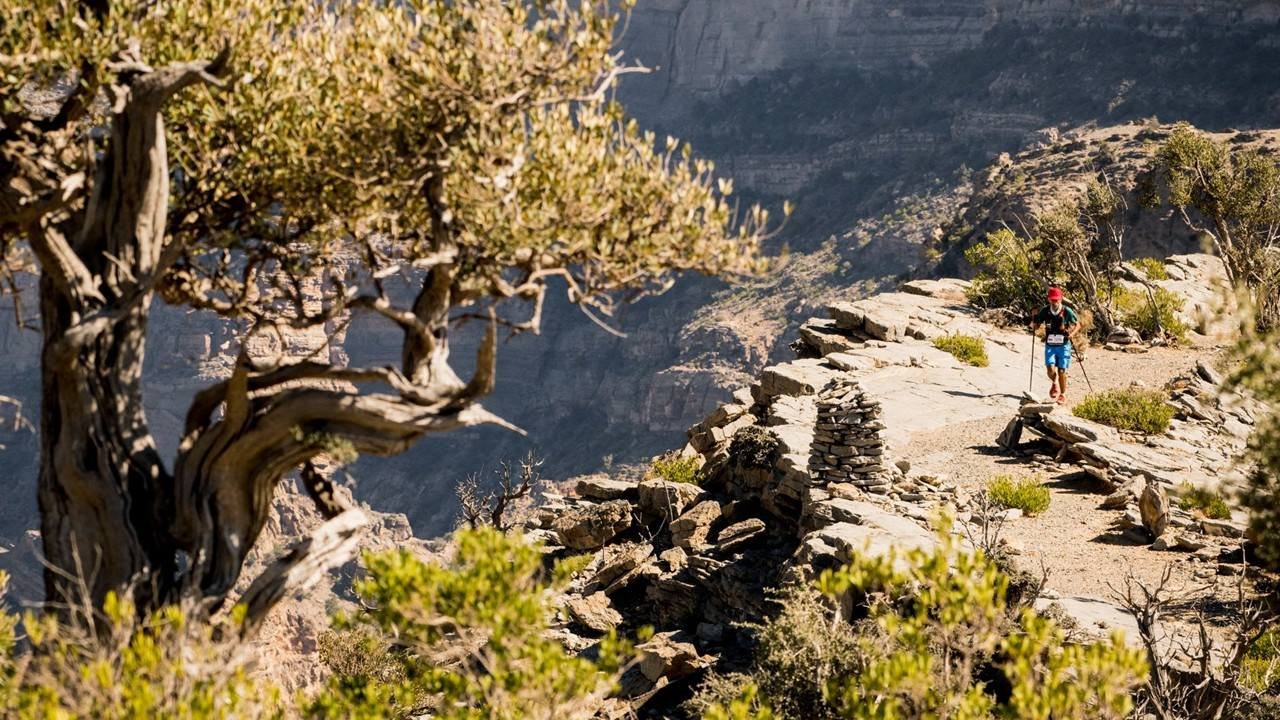 Trail runner navigating a rocky ridgeline in the Hajar Mountains at Oman by UTMB 2026