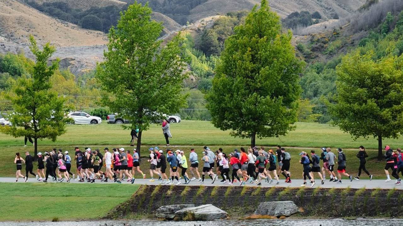 Runners on the Queenstown Marathon course with the Remarkables mountain range in the background
