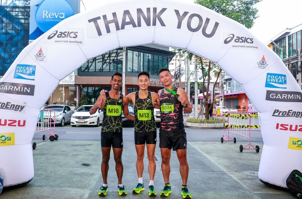 Three runners celebrating at finish line.
