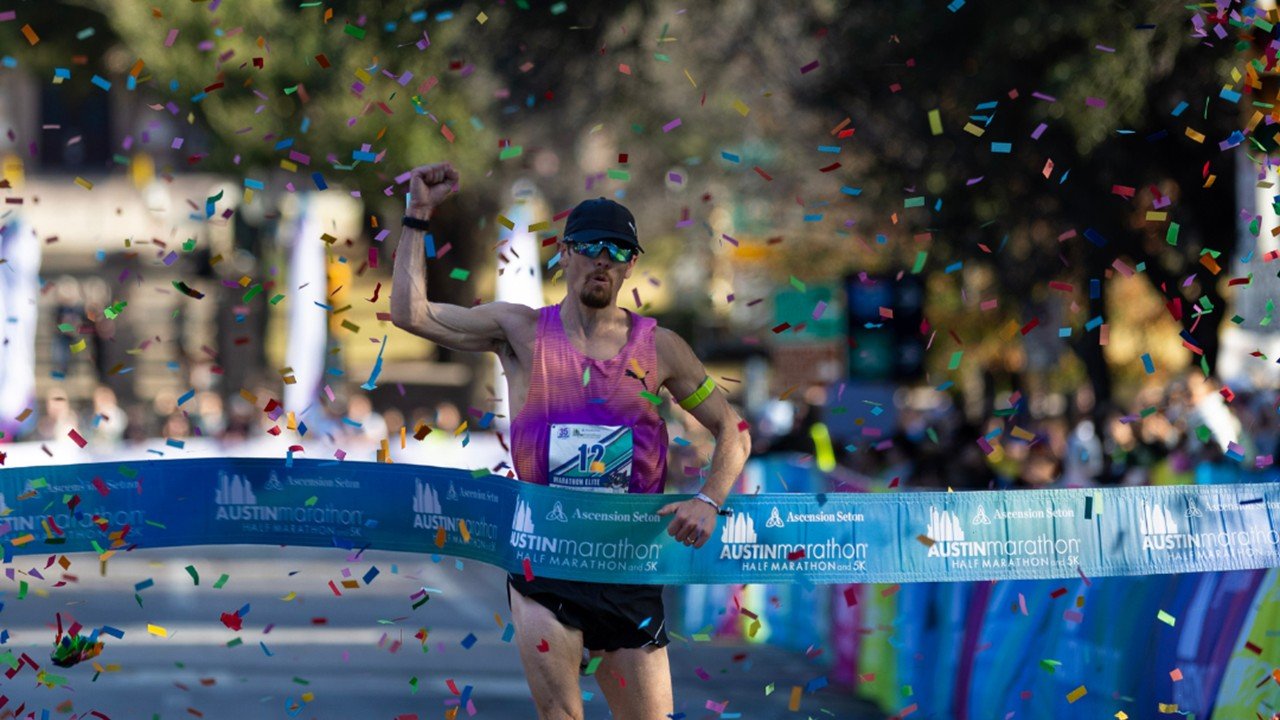 Runners racing toward the finish line on Congress Avenue at the Austin Marathon with the Texas State Capitol in the background