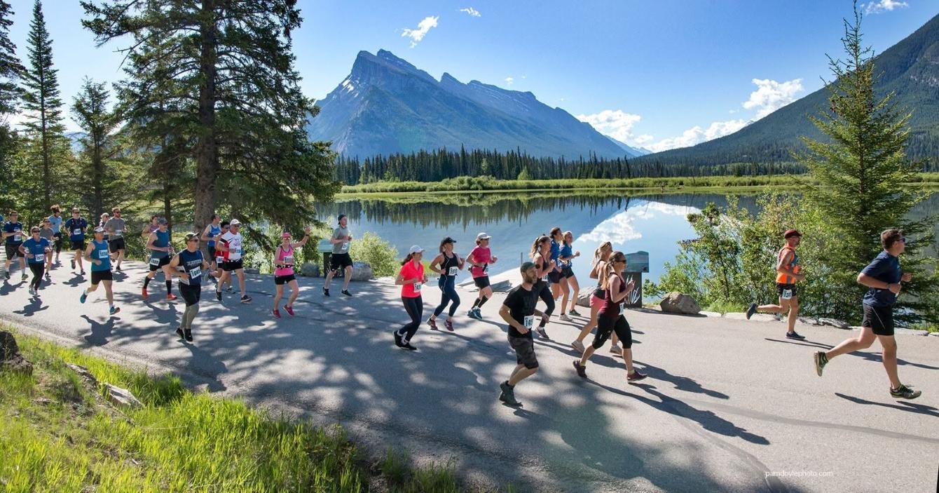 Runners racing along the Bow Valley Parkway at the Banff Half Marathon with the Canadian Rockies in the background