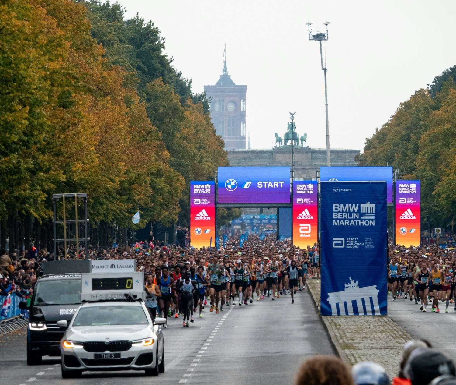 Runners at the BMW Berlin Marathon start line on Strasse des 17 Juni with the Brandenburg Gate in the background