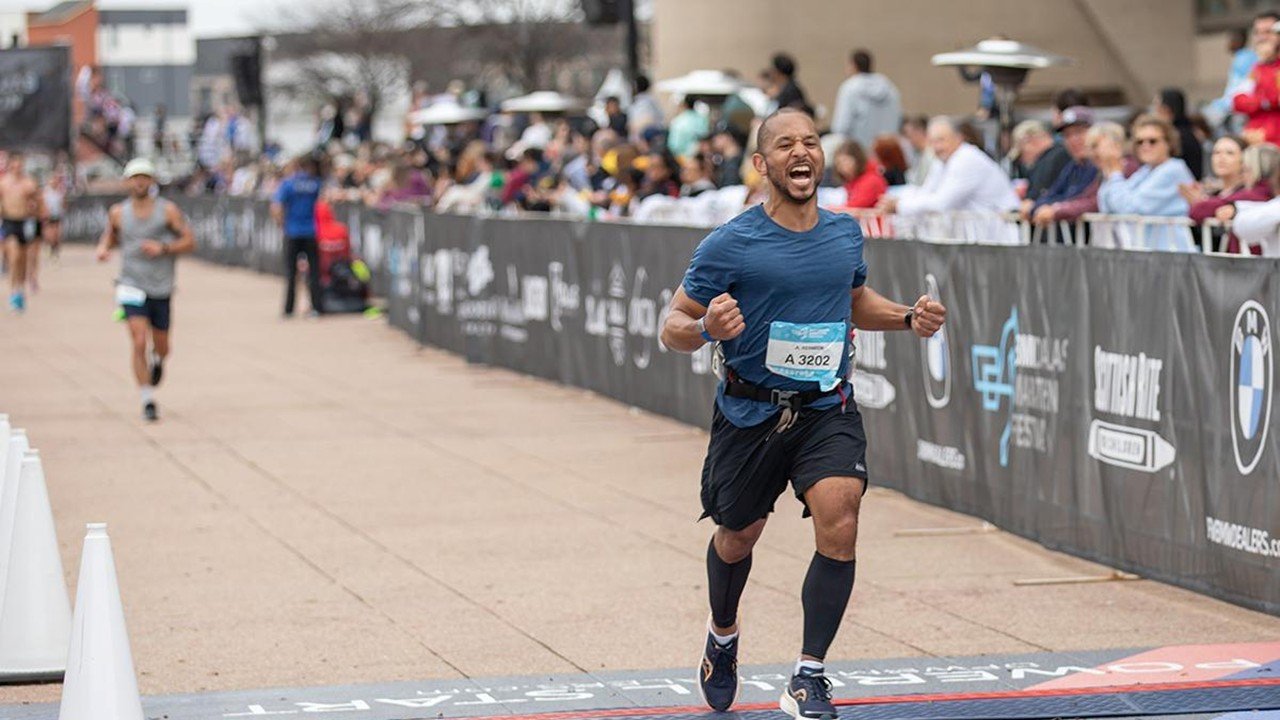 Runners competing at the BMW Dallas Marathon in downtown Dallas with City Hall in the background