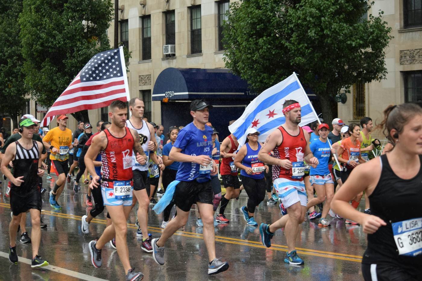 Runners carrying the Chicago city flag and American flag during the Bank of America Chicago Marathon
