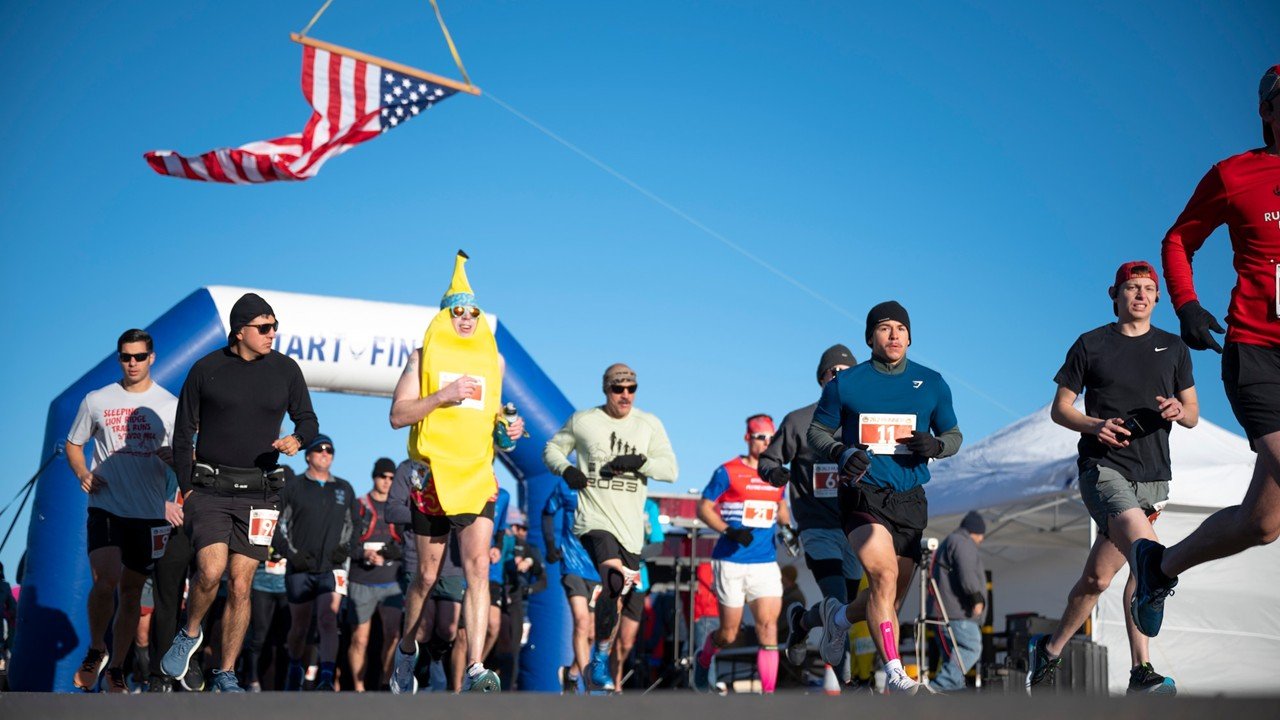 Runners at the start of the Holloman Ace of Races marathon on the flightline at Holloman Air Force Base, New Mexico, with military aircraft in the background