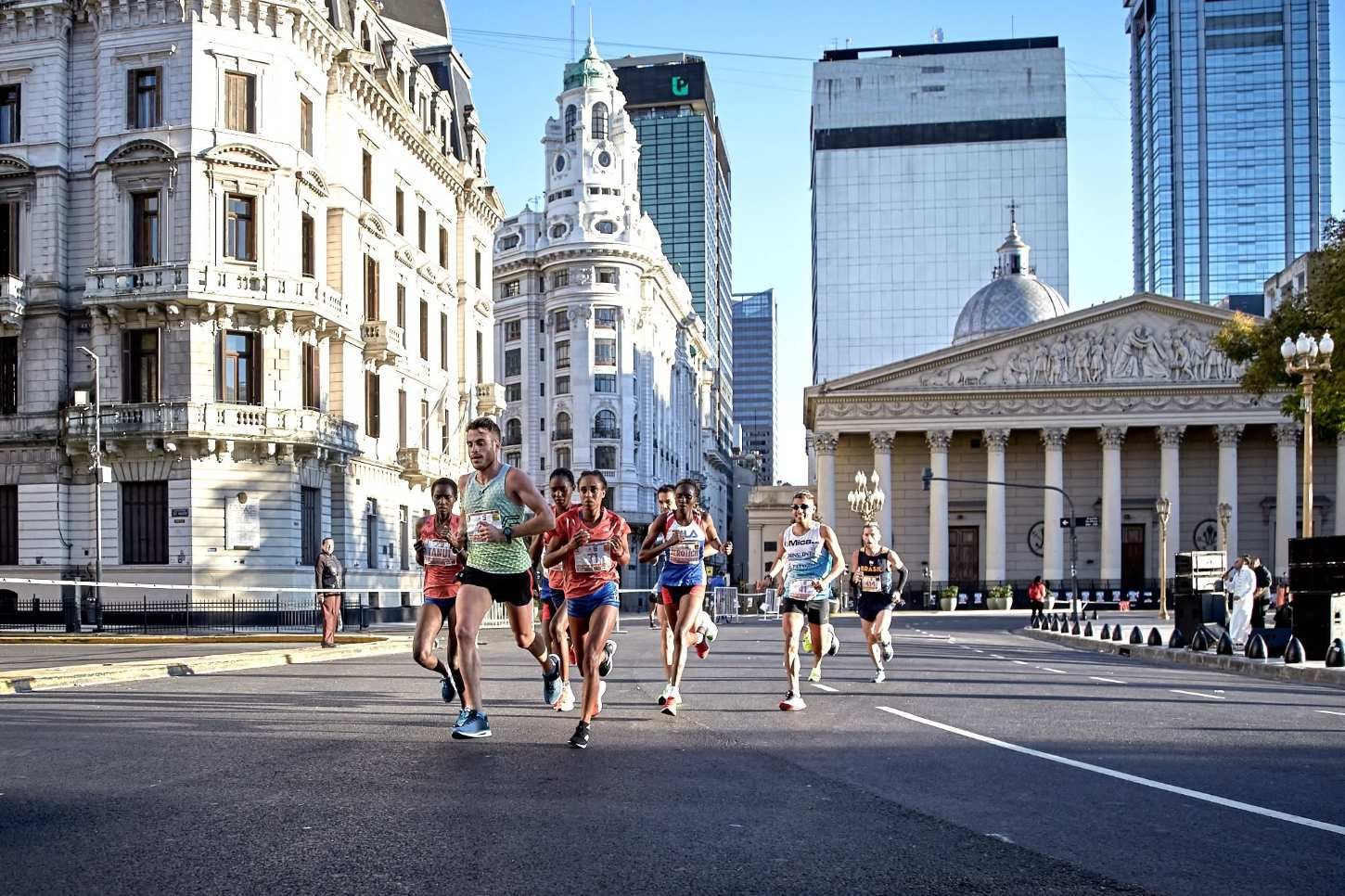 Runners racing through the streets of Buenos Aires at the 2026 Maratón Internacional de Buenos Aires, with the city's colonial architecture and modern skyline in the background