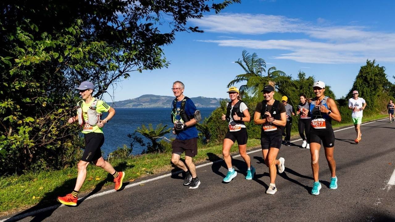 Runners racing along the lakeside course at the Red Stag Rotorua Marathon with Lake Rotorua in the background