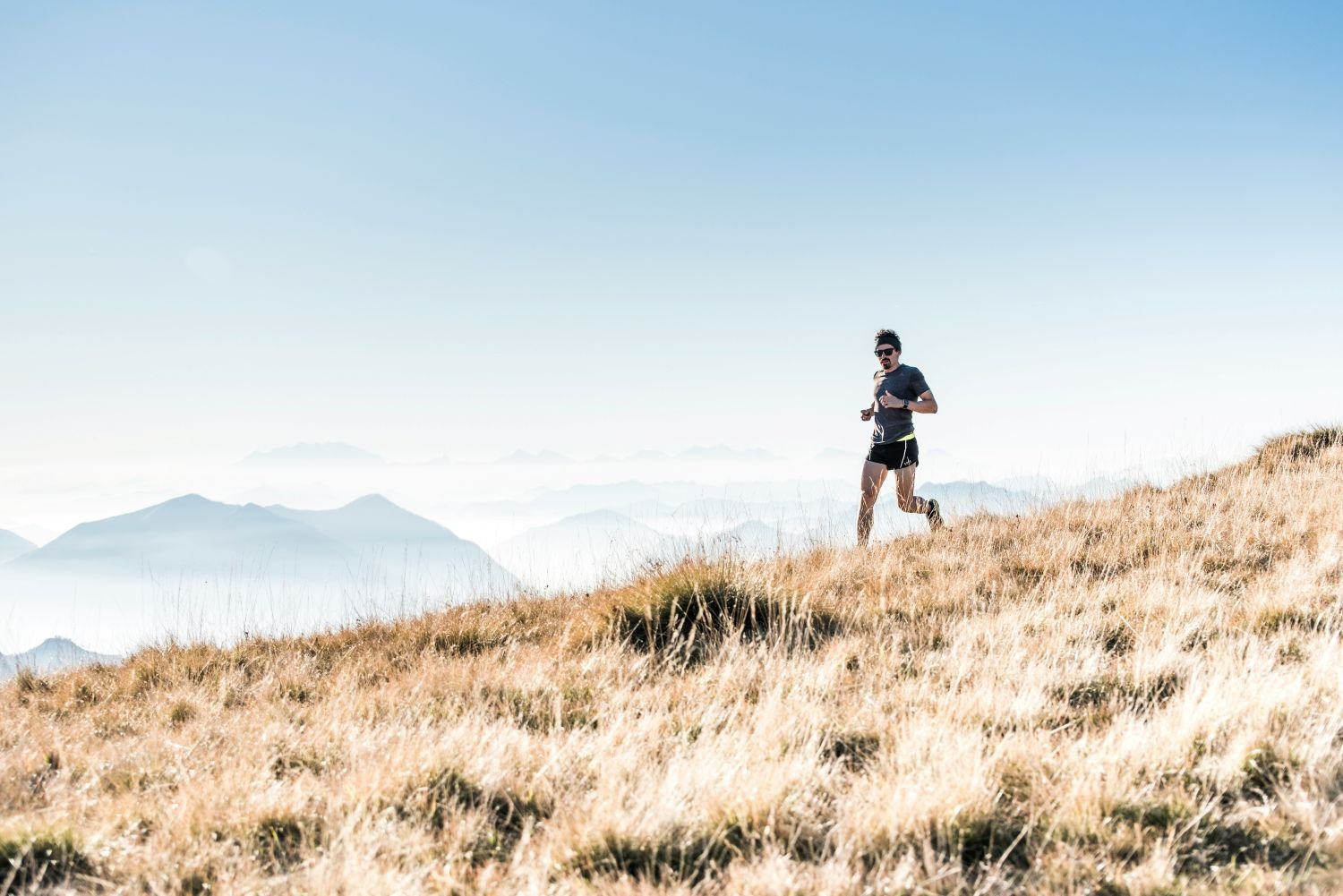 Trail runner on a dry mountain ridge with hazy smoke-filled skies in the background