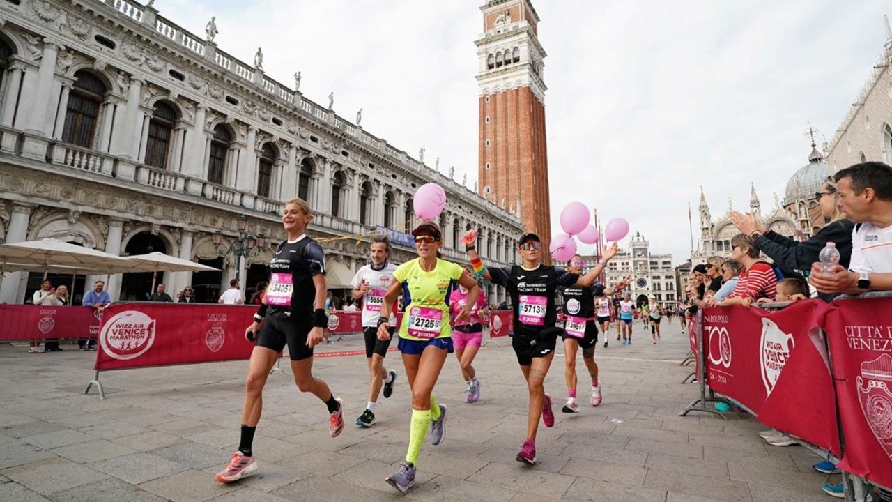 Venice Marathon 2026: Complete Race Guide, Course & Tips 2 Runners competing in the Venice Marathon crossing the bridges of Venice