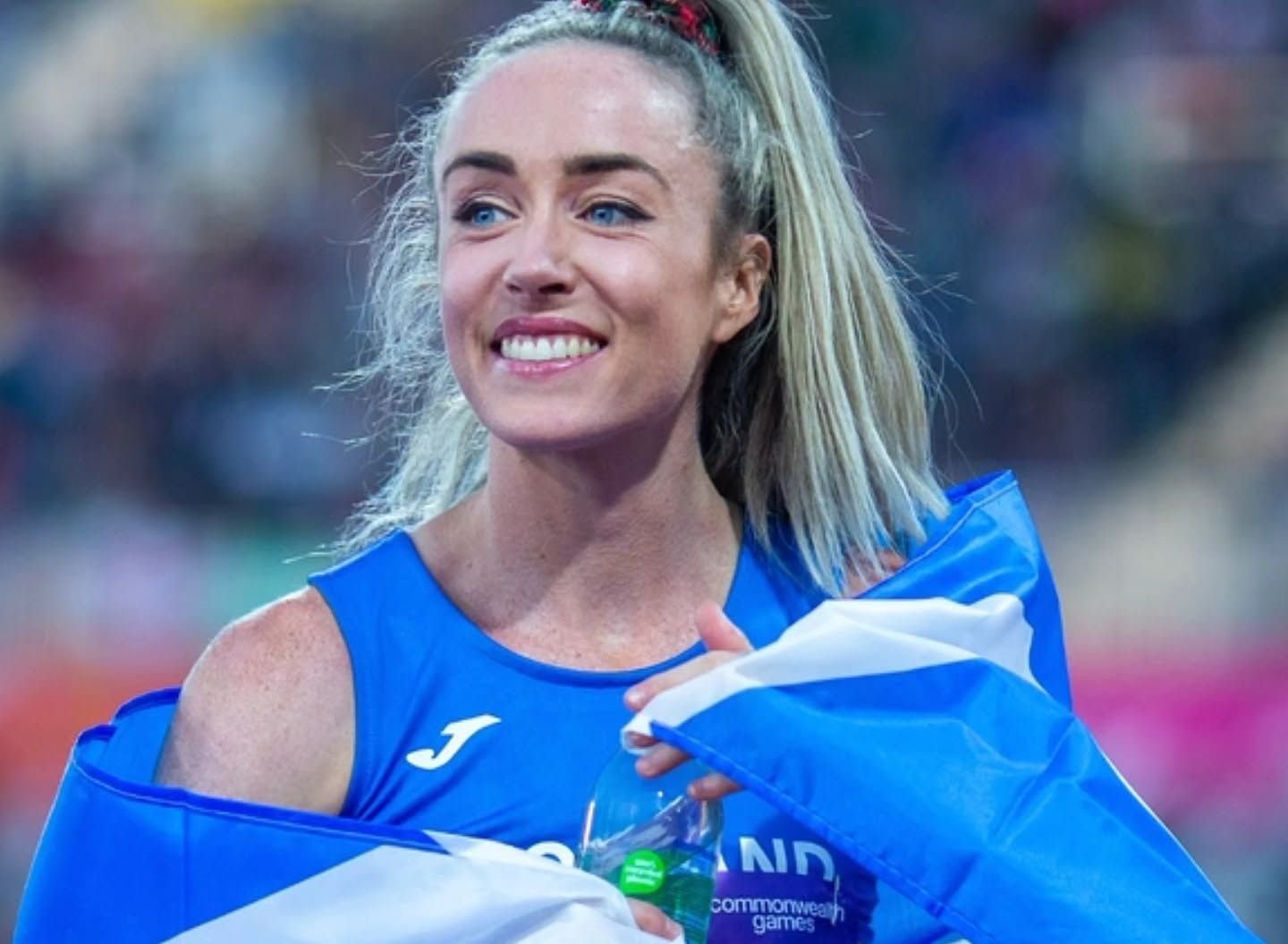 Eilish McColgan wrapped in the Scottish Saltire flag after her Commonwealth Games 10,000m win