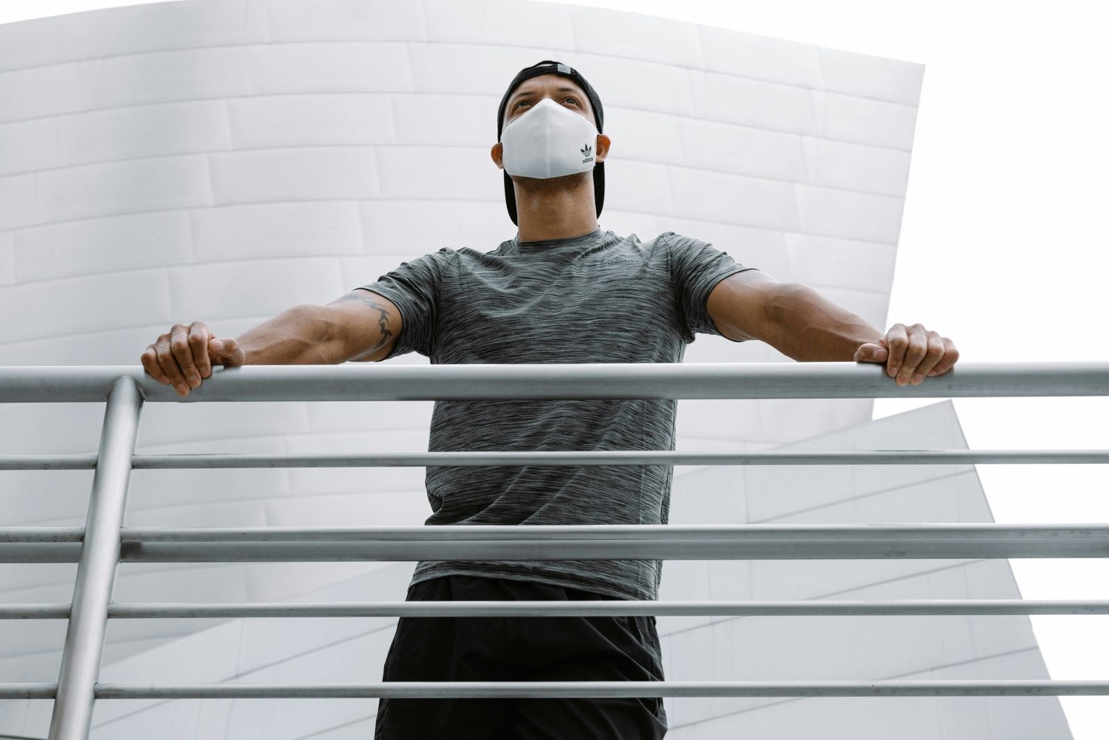 Runner wearing a white pollution mask standing outdoors in an urban setting