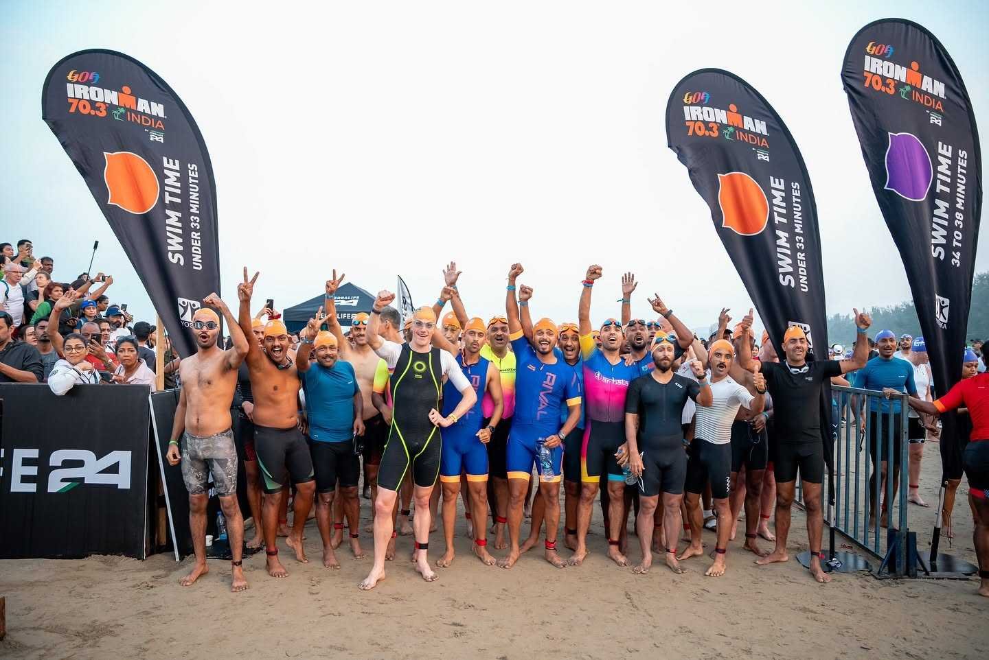 Athletes in orange swim caps gather at the IRONMAN 70.3 Goa start line on Miramar Beach, Panaji, ahead of the 1.9 km open-water swim into the Arabian Sea