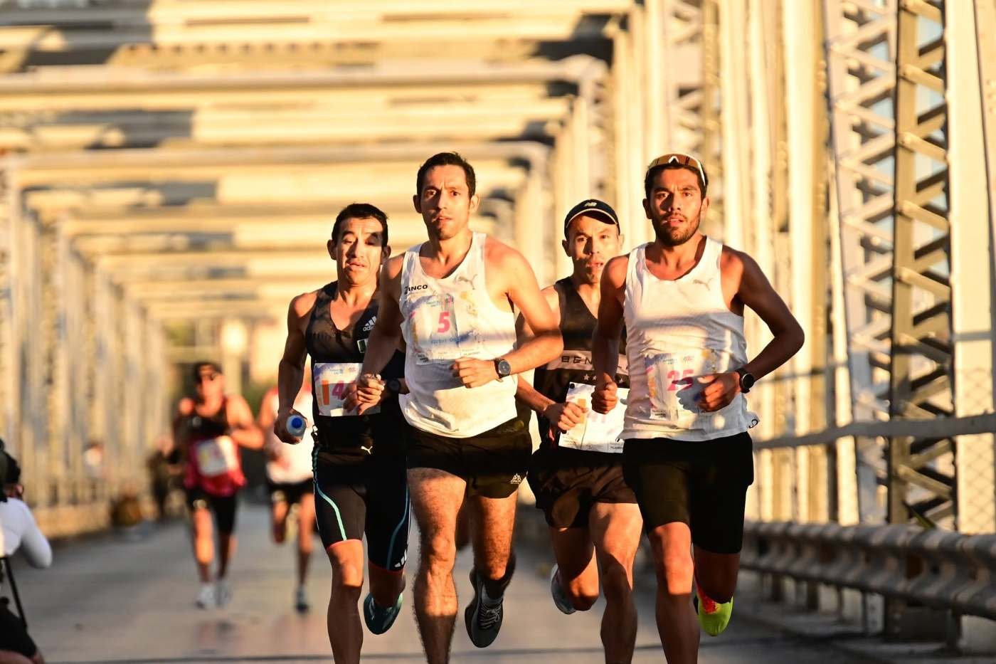 Elite runners crossing a bridge at the Maratón Internacional Lala in La Comarca Lagunera, Mexico