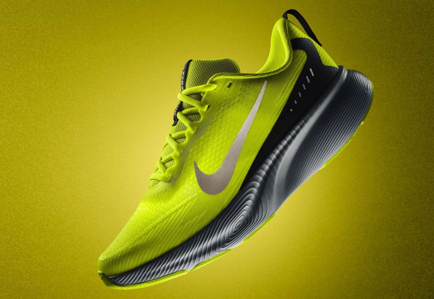 Nike Vegam Run in volt yellow-green colourway with dark grey midsole, shown in floating product shot against a matching yellow-green background