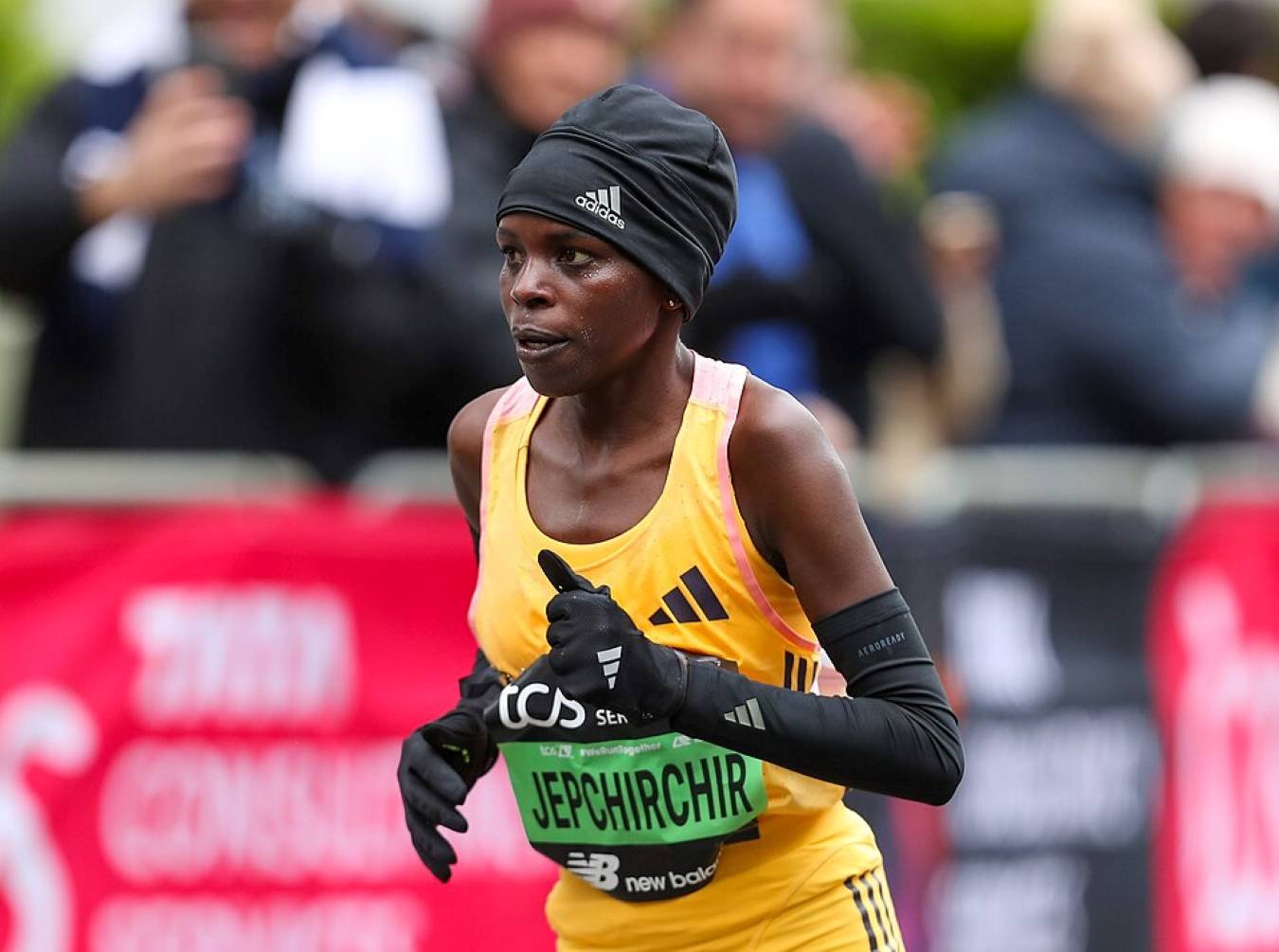 Peres Jepchirchir running at mile 18 of the 2024 TCS London Marathon, wearing an Adidas vest and TCS race bib