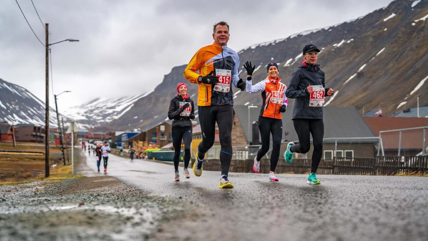 Runners on the Spitsbergen Marathon course with Arctic mountains and valley behind them, Longyearbyen, Svalbard