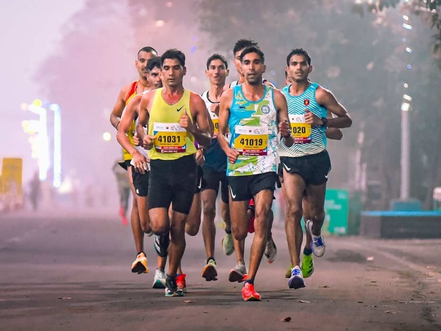 Indian elite men racing through early morning mist on Red Road at the Tata Steel World 25K Kolkata