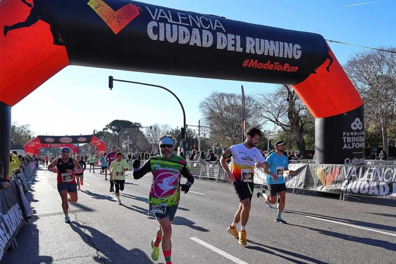 Runners passing under the Valencia Ciudad del Running arch on race day