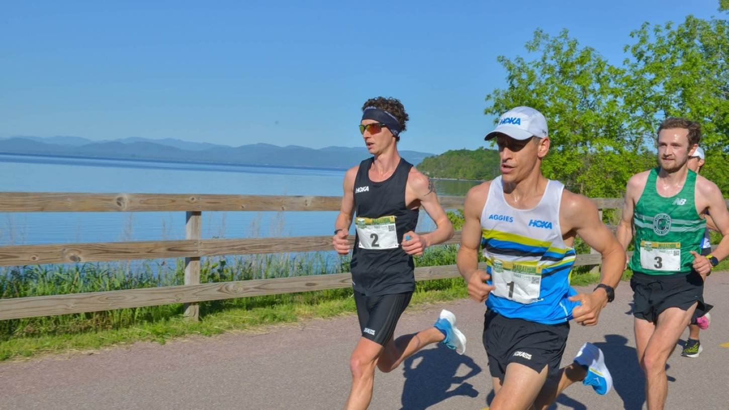 Lead runners on the Burlington Bike Path during the Vermont City Marathon, with Lake Champlain and the Adirondack Mountains in the background
